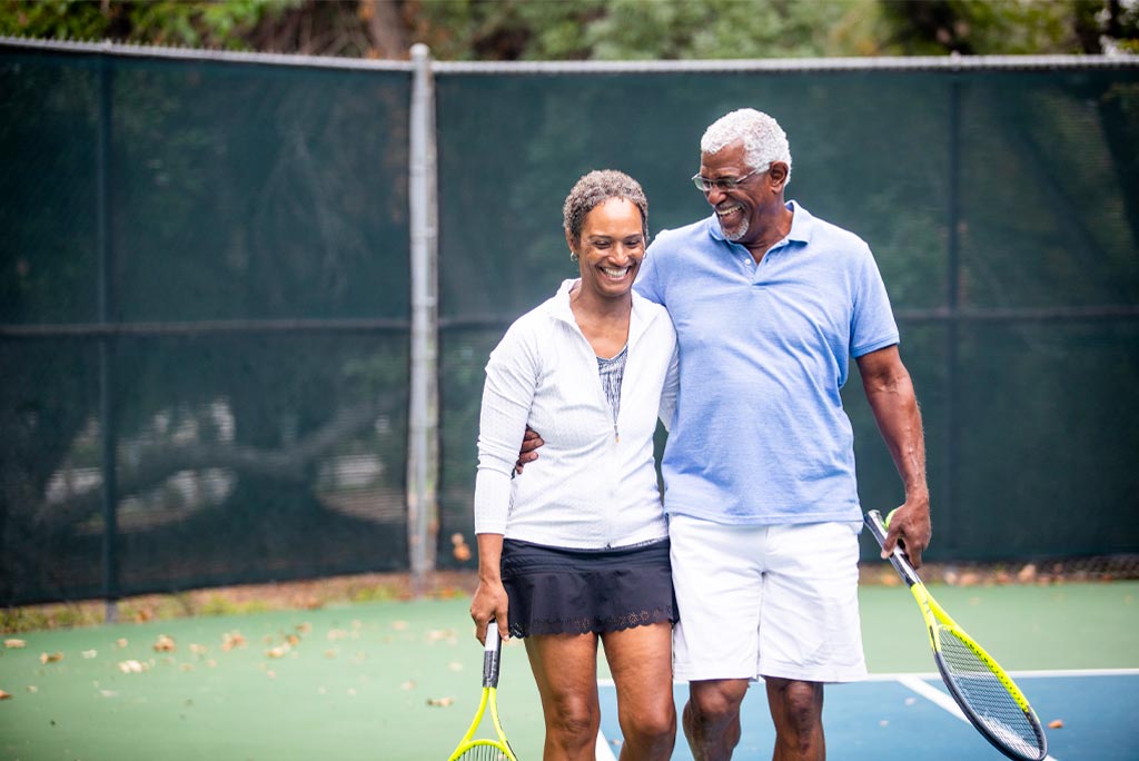 A man and a woman playing tennis together.